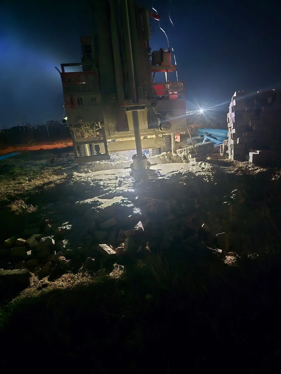 A drilling rig working under lights at night on the Kanyemba site